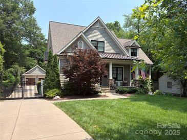 Charming two-story home featuring a landscaped yard, covered porch, and gated driveway at 2941 Forest Park Dr, Charlotte, NC 28209