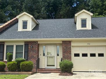Charming single-Gathering home featuring a brick facade, dormer windows, and an attached garage at 550 Camrose Ne Cir, Concord, NC 28025