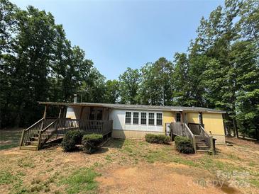 Charming single-story home featuring a covered porch and set amidst a lush, wooded landscape at 7389 Shiloh Unity Rd, Lancaster, SC 29720