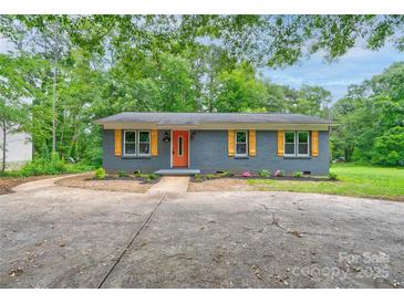 Charming single-story home featuring a brick facade, orange door, and yellow shutters at 1010 Fallston Rd, Shelby, NC 28150