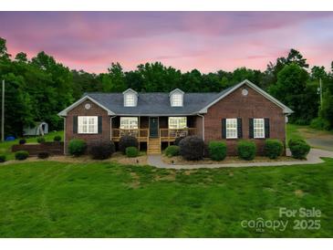 Charming brick home featuring a well-manicured lawn and a cozy front porch at 1060 S Lentz Harness Shop Rd, Mount Pleasant, NC 28124