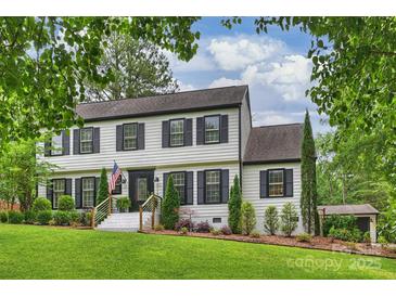 Charming two-story home with a lush green lawn and beautiful landscaping at 1119 Thornsby Ln, Matthews, NC 28105