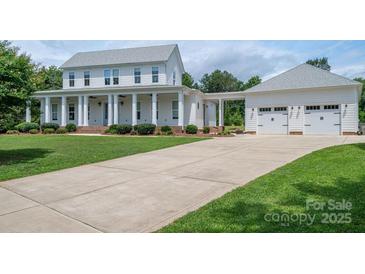 Inviting two-story home with a large front yard, driveway, and a detached three-car garage at 1621 Lakefield Cir, Gastonia, NC 28056