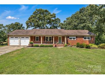 Charming brick home with a two-car garage, lush lawn, and manicured landscaping at 2010 Dogwood Trl, Shelby, NC 28150
