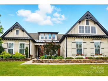 Charming home featuring a manicured lawn, stone accents, and symmetrical architectural details at 5357 Pembrey Dr, Denver, NC 28037