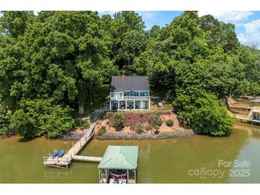 Beautiful waterfront home featuring a private dock and boat house surrounded by lush trees at 812 Bell Post Rd, Belmont, NC 28012