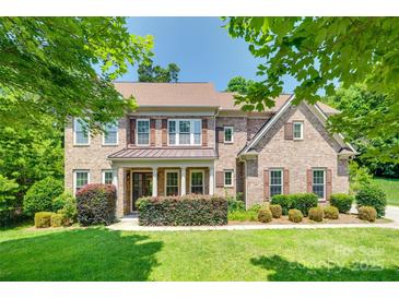 Charming two-story brick home with manicured lawn, mature trees, and a covered front porch at 2785 Disney Pl, Indian Land, SC 29707