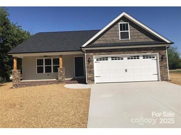 Charming home featuring a two-car garage, covered porch with stone columns, and varied siding textures at 670 Fisher Dr # 2, Rockwell, NC 28138