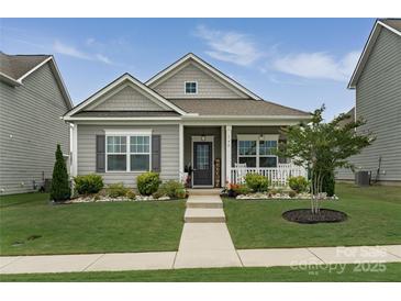 Charming single-story home with a welcoming front porch and well-manicured lawn at 148 Kerri Dawn Ln, Locust, NC 28097