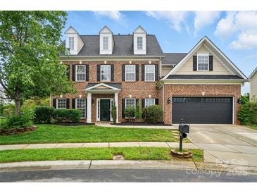 Traditional two-story brick home featuring a manicured lawn and attached two-car garage at 1522 Napa Nw St, Concord, NC 28027