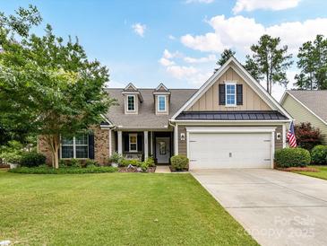 Charming two-story home with a well-manicured lawn, beautiful landscaping, and an attached two-car garage at 200 Sweet Briar Dr, Fort Mill, SC 29707