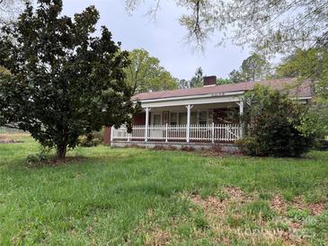 Charming single-story home with a cozy front porch and white picket fence, surrounded by green grass at 2096 S Point Rd, Belmont, NC 28012