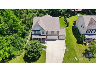 Two-story home boasts a spacious driveway, lush lawn, and mature trees for a serene setting at 3106 Crosswind Dr, Fort Mill, SC 29707