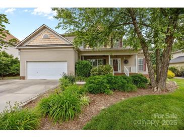 Charming home with a well-maintained lawn, mature landscaping, and a cozy front porch at 6533 Derby Nw Ln, Concord, NC 28027