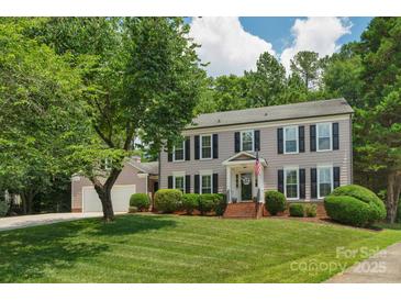 Charming two-story home features a well-manicured lawn, lush landscaping, and inviting curb appeal at 9423 Wood Ridge Dr, Charlotte, NC 28277