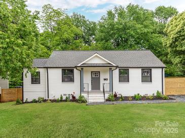 Charming home featuring a white brick facade, well-manicured lawn, and classic architectural details at 2114 Thurmond Pl, Charlotte, NC 28205