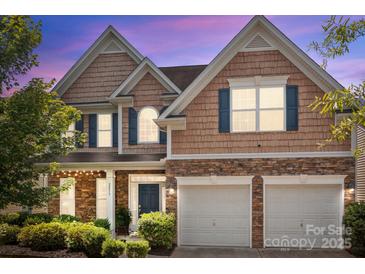 Charming two-story home boasts a manicured lawn, stone accents, and a two-car garage at 2233 Sonoma Valley Dr, Charlotte, NC 28214