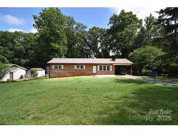 Charming brick home with a metal roof, spacious front yard, and a convenient carport at 2625 Glenn St, Newton, NC 28658