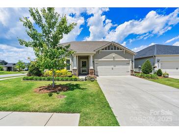 Charming single-story home boasts a well-manicured lawn, mature tree, and an inviting two-car garage at 4197 Canopy Creek Dr, Denver, NC 28037