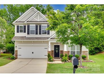 Charming two-story home features a two-car garage, stone accents, and a welcoming front porch at 424 Castlebury Ct, Clover, SC 29710
