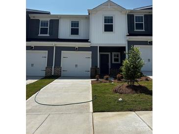 New construction two story townhouse with light gray siding, white trim and white garage door at 6122 Starview Ter, Charlotte, NC 28216
