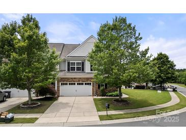 Charming two-story home with a brick and siding facade, large windows, mature trees, and a two-car garage at 7130 Maricopa Rd, Charlotte, NC 28277