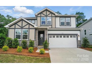 Charming two-story home with stone accents, a well-manicured yard and a two car garage at 9957 Cask Way, Huntersville, NC 28078