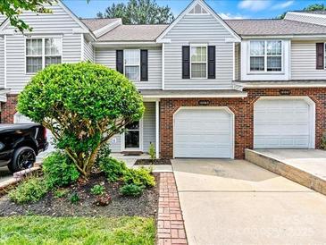 Charming townhome with attached garage, manicured landscaping, and neutral siding for inviting curb appeal at 10063 Reindeer Way Ln, Charlotte, NC 28216