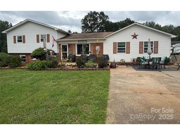 Charming home with a lush lawn, beautiful landscaping, and inviting outdoor seating area at 1895 Sandy Cir, Newton, NC 28658