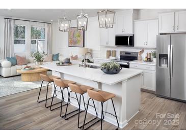 Bright kitchen with white cabinets, stainless steel appliances, and a large island with bar seating at 2485 Hedgecliff Rd, Kannapolis, NC 28025