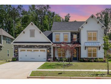 Charming two-story home with a stone-accented garage, front lawn, and professionally landscaped yard at 482 Lucky Nw Dr, Concord, NC 28027