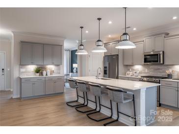 Modern kitchen features a large island with seating and stainless steel appliances at 5948 Chumbley Point Rd # 79, Charlotte, NC 28215