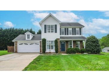 Charming two-story home featuring a lush green lawn, attached garage, and classic architectural details at 600 Capella Ct, Gastonia, NC 28056