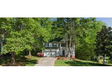 Charming two-story home with green roof, attached garage, and mature trees at 8731 Woodhill Manor Ct, Charlotte, NC 28215