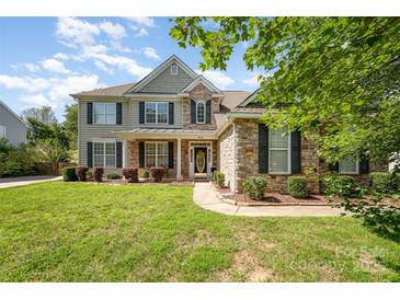 Charming two-story home with a stone and siding exterior, black shutters, and a well-manicured lawn at 9814 Tompkins Ln, Waxhaw, NC 28173