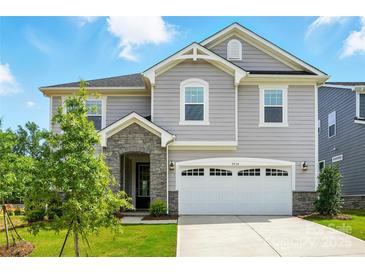 Charming two-story home boasts a two-car garage, stone accents, manicured lawn, and inviting curb appeal at 9934 Cask Way, Huntersville, NC 28078