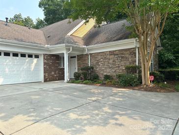 Charming home featuring a brick and stone facade, well-maintained landscaping, and a two-car garage at 10875 Casetta Dr, Matthews, NC 28105