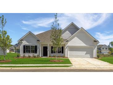 Charming single-story home featuring a manicured lawn, a two-car garage, and classic architectural details at 12184 Muscadine Ct, Midland, NC 28107