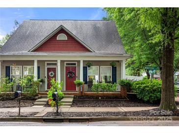 Charming home featuring a welcoming facade with dual entrances, red trim, and tasteful landscaping at 12663 Windyedge Rd, Huntersville, NC 28078