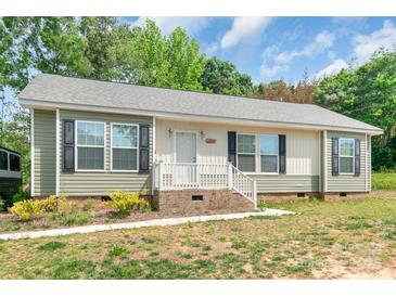 Charming single-story home features neutral siding, black shutters, well-maintained yard, and inviting front porch at 1316 Wiscassett St, Albemarle, NC 28001