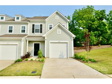 Inviting townhome featuring a well-manicured lawn and an attached one-car garage, providing both curb appeal and practicality at 1365 Eagle Claw Dr, Kannapolis, NC 28083