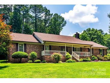 Charming brick home featuring a inviting front porch and meticulously landscaped front yard at 2209 Cardinal Loop, Stanley, NC 28164