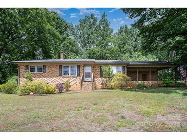 Charming brick home with covered porch and mature trees on a sunny day at 2631 Ivey Church Rd, Lincolnton, NC 28092