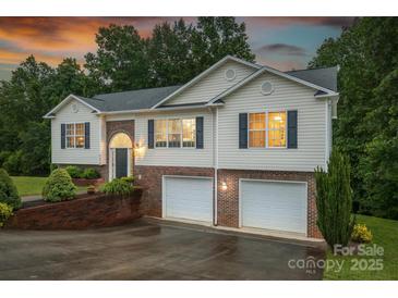 Charming two-story home featuring a brick facade, vinyl siding, and an attached two-car garage at 4059 Caitlins Way, Hickory, NC 28602