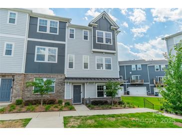 Charming townhouse with a mix of brick and siding and manicured front yard with beautiful landscaping at 4439 Millennium Ave, Charlotte, NC 28217