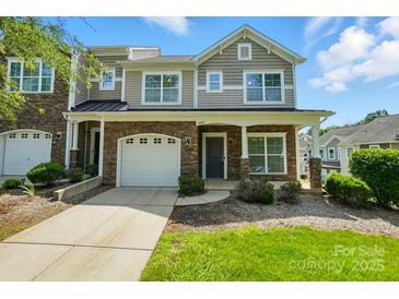 Charming townhome featuring a stone facade, attached garage, and well-maintained front lawn at 6333 Cory Bret Ln, Charlotte, NC 28278