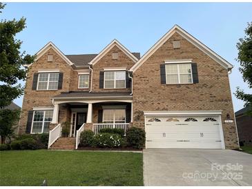 Charming two-story brick home featuring a manicured lawn and an attached two-car garage at 707 Five Leaf Ln, Waxhaw, NC 28173