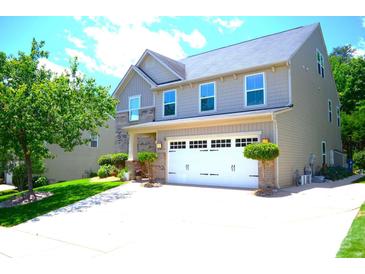 Charming two-story home with a two-car garage, lush landscaping, and a well-manicured lawn at 7170 Kenyon Dr, Denver, NC 28037