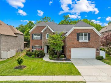 Beautiful two-story brick home with a manicured lawn and an attached two-car garage at 8460 Fairgreen Ave, Waxhaw, NC 28173