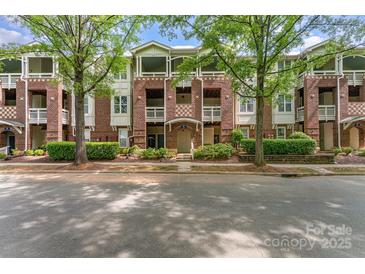Charming brick condo building featuring multiple stories, well-maintained landscaping, and covered balconies at 915 Northeast Dr # 15, Davidson, NC 28036